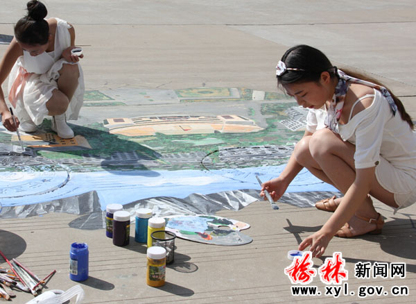 图为学生正在井盖涂鸦